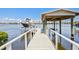 Private boat dock with a covered lift and swing overlooking the serene water at 644 Bayshore Dr, Tarpon Springs, FL 34689
