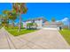 Well-manicured home featuring mature palms and a driveway leading to an attached garage at 644 Bayshore Dr, Tarpon Springs, FL 34689