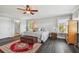 A spacious main bedroom featuring hardwood floors, natural light, ceiling fan, and ensuite access at 644 Bayshore Dr, Tarpon Springs, FL 34689