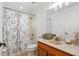 Clean bathroom with floral shower curtain and wood vanity at 7187 50Th Avenue E Cir, Palmetto, FL 34221