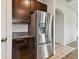 Stainless steel refrigerator in kitchen with dark wood cabinets at 12235 Creek Preserve Dr, Riverview, FL 33579