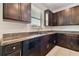 Modern kitchen with dark wood cabinets, granite countertops, and stainless steel appliances at 12235 Creek Preserve Dr, Riverview, FL 33579