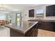 Modern kitchen with dark wood cabinets, granite countertops, and stainless steel appliances at 12235 Creek Preserve Dr, Riverview, FL 33579