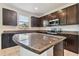Modern kitchen with dark wood cabinets, granite countertops, and stainless steel appliances at 12235 Creek Preserve Dr, Riverview, FL 33579