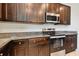 Kitchen with stainless steel appliances and dark wood cabinets at 12235 Creek Preserve Dr, Riverview, FL 33579