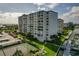 Multi-story condo building with manicured grounds, tennis court, and marina access at 660 Island Way # 301, Clearwater Beach, FL 33767