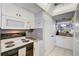Kitchen with white cabinets, granite counters, and view into living area at 1730 Manasota Beach Rd # 115, Englewood, FL 34223