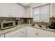 Corner kitchen with granite countertops and white cabinets at 1730 Manasota Beach Rd # 115, Englewood, FL 34223
