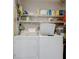 Laundry room with washer, dryer, and shelving for storage at 1730 Manasota Beach Rd # 115, Englewood, FL 34223