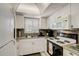 Well-equipped kitchen featuring white cabinets and granite countertops at 1730 Manasota Beach Rd # 115, Englewood, FL 34223