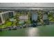 Aerial view of waterfront community with pools, tennis courts, boat slips, and lush landscaping at 660 Island Way # 301, Clearwater Beach, FL 33767