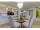 Elegant dining area with glass-top table and modern chandelier at 4450 Gulf Blvd # 104, St Pete Beach, FL 33706