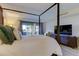 Spacious main bedroom with a comfy bed and large TV at 4450 Gulf Blvd # 104, St Pete Beach, FL 33706