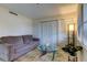 Living room with gray sofa, coffee table, and large windows at 4450 Gulf Blvd # 104, St Pete Beach, FL 33706