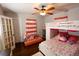 Colorful bedroom with a bunk bed, hardwood floors, and coral curtains at 5501 Bates St, Seminole, FL 33772