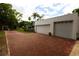 Two-car garage with white doors and a brick paved driveway at 5501 Bates St, Seminole, FL 33772