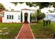 Front view of a charming two-story house with a red brick walkway and landscaping at 5501 Bates St, Seminole, FL 33772