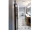Spa-like bathroom with double sinks, patterned wallpaper, and a walk-in shower at 5501 Bates St, Seminole, FL 33772