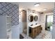 Modern bathroom with double vanity, patterned wallpaper, and tiled floors at 5501 Bates St, Seminole, FL 33772