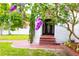 Front entrance view with a red brick walkway, arched entryway, and flowering trees at 5501 Bates St, Seminole, FL 33772