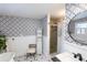Stylish bathroom with a walk-in shower, patterned wallpaper and a freestanding tub at 5501 Bates St, Seminole, FL 33772
