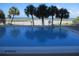 Swimming pool with views of the beach and palm trees beyond a protective fence at 11000 Gulf Blvd # 301, Treasure Island, FL 33706