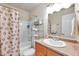 Clean bathroom with tub shower, vanity, and shelving at 5157 Beach Se Dr # C, St Petersburg, FL 33705