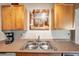 Kitchen with double sink, light wood cabinets and a charming wall art at 5157 Beach Se Dr # C, St Petersburg, FL 33705