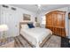 Bedroom featuring a wooden armoire, ceiling fan, white bedding, and patterned rug at 1049 Marine St, Clearwater, FL 33755