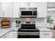 Close-up of the stainless steel stove and microwave in the renovated kitchen at 1049 Marine St, Clearwater, FL 33755