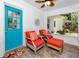 Bright sunroom with a teal door, wooden furniture, and serene neighborhood views at 1049 Marine St, Clearwater, FL 33755