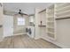 Bright laundry room with washer, dryer, ample shelving, and built-in storage at 1200 Eden Isle Ne Blvd, St Petersburg, FL 33704