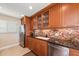Modern kitchen with granite countertops, stainless steel appliances, and wood cabinets at 400 Larboard Way # 106, Clearwater Beach, FL 33767