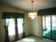 Bright dining room with a chandelier, window curtains, and access to a sunroom at 231 Tarpon Ln, Oldsmar, FL 34677