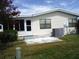 Rear view of manufactured home with patio and AC unit at 231 Tarpon Ln, Oldsmar, FL 34677