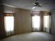 Well-lit bedroom with three windows and ceiling fan at 231 Tarpon Ln, Oldsmar, FL 34677