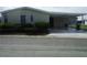 Front view of manufactured home with carport and landscaping at 231 Tarpon Ln, Oldsmar, FL 34677