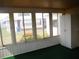 Sunroom with green carpeting, multiple windows, and a view of the backyard at 231 Tarpon Ln, Oldsmar, FL 34677