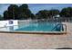 Community pool with brick deck and surrounding trees at 231 Tarpon Ln, Oldsmar, FL 34677