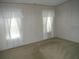 Spacious bedroom with neutral carpeting and two bright windows at 231 Tarpon Ln, Oldsmar, FL 34677
