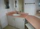 Double vanity with a pink countertop and bench at 231 Tarpon Ln, Oldsmar, FL 34677