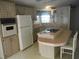 A galley-style kitchen with light-colored cabinets, built-in appliances, and a center island at 231 Tarpon Ln, Oldsmar, FL 34677