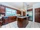 Spacious kitchen featuring dark wood cabinetry, stainless steel appliances, and an island at 1142 Weybridge Ln, Dunedin, FL 34698