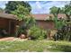 Landscaped front yard with stone accents, a small patio area, and vibrant greenery enhancing curb appeal at 8665 Mockingbird Ln, Seminole, FL 33777