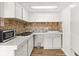 Small galley kitchen with white cabinets and tile backsplash at 4001 58Th N St # 16, Kenneth City, FL 33709