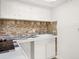 Small galley kitchen with white cabinets and tile backsplash at 4001 58Th N St # 16, Kenneth City, FL 33709