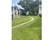 Curving concrete path through grassy area, leads to residential buildings at 2625 State Road 590 # 2711, Clearwater, FL 33759