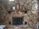 Stone fireplace with wood mantel and decorative items at 8665 Mockingbird Ln, Seminole, FL 33777