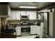A kitchen with white cabinets and appliances at 8665 Mockingbird Ln, Seminole, FL 33777