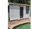 White pool shed with a door and window, near the pool at 8665 Mockingbird Ln, Seminole, FL 33777